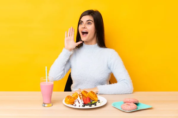 Young Woman Eating Waffles Milkshake Table Isolated Yellow Background Shouting — Stock Photo, Image