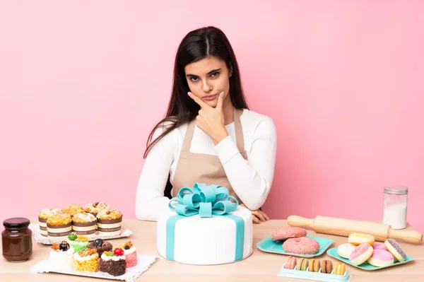 Konditor Mit Einem Großen Kuchen Einem Tisch Über Isoliertem Rosa — Stockfoto