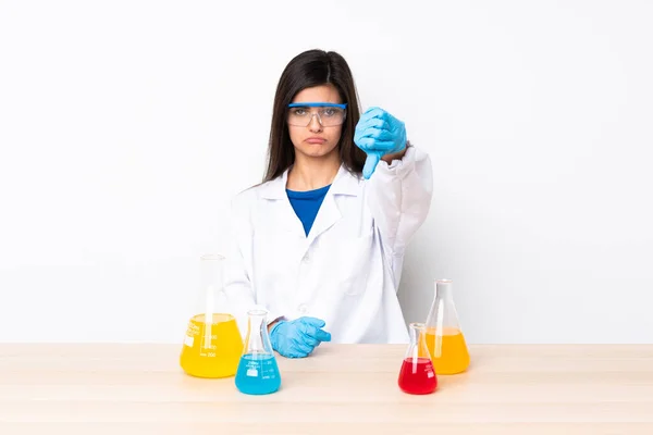 一个年轻的科学女人在一张带着负面表情的桌子上垂头丧气 — 图库照片
