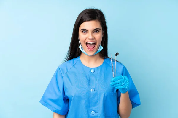 Ung Kvinna Tandläkare Hålla Verktyg Över Isolerad Blå Bakgrund Med — Stockfoto