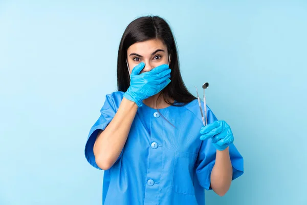 Mujer Joven Dentista Sosteniendo Herramientas Sobre Fondo Azul Aislado Con —  Fotos de Stock