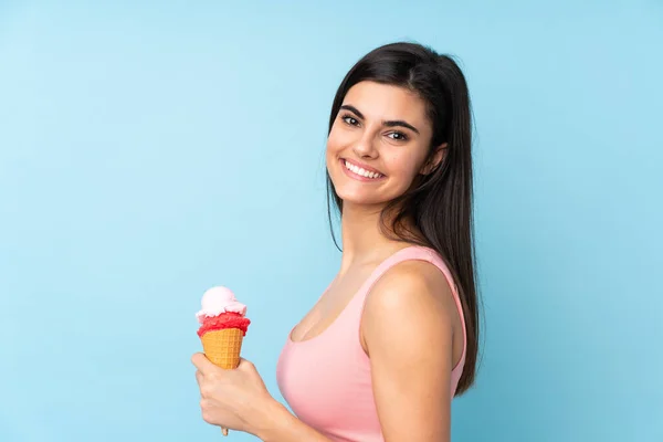 Jonge Vrouw Met Een Cornet Ijs Geïsoleerde Blauwe Achtergrond Glimlachen — Stockfoto