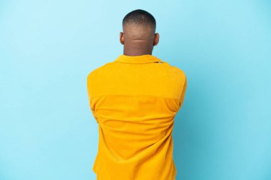 Genç latin adam arka planda mavi arka planda izole edilmiş.