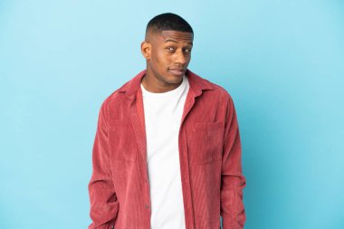 Genç latin adam mavi arka planda izole edilmiş.