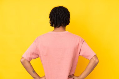 Genç Afrikalı Amerikalı adam sarı arka planda izole edildi.