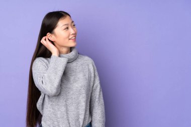 Asyalı genç bir kadın izole edilmiş bir arka planda bir fikir düşünüyor.