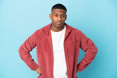 Genç latin adam mavi arka planda izole edilmiş kızgın.