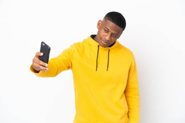 Beyaz arka planda izole edilmiş genç Latin bir adam selfie çekiyor.