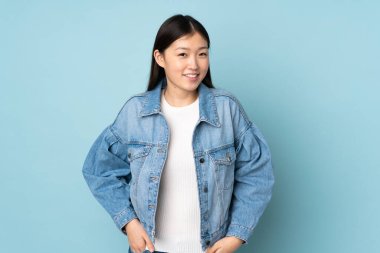 Genç Asyalı kadın arka planda yalnız gülüyor.