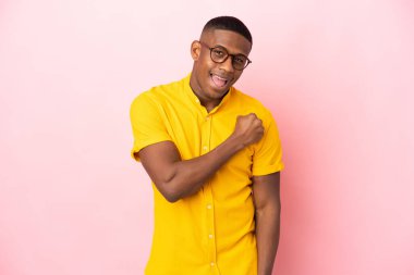 Pembe arka planda izole edilmiş genç latin adam zaferi kutluyor.