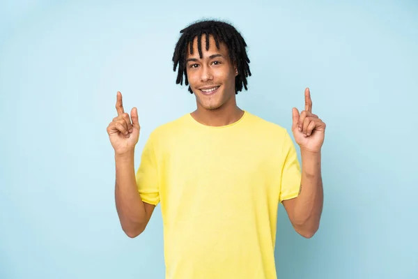 Jovem Afro Americano Isolado Fundo Azul Apontando Para Uma Grande — Fotografia de Stock