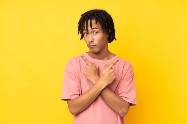 Joven Hombre Afroamericano Aislado Sobre Fondo Amarillo Apuntando Los Laterales — Foto de Stock