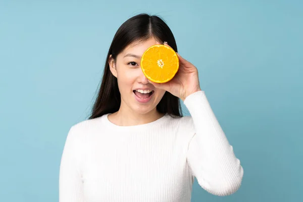 Ung Asiatisk Kvinna Som Håller Orange Över Isolerad Blå Bakgrund — Stockfoto