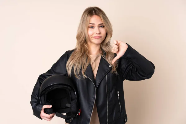 오토바이 헬멧을 러시아 소녀의 엄지를 아래로 베이지 고립되어 — 스톡 사진
