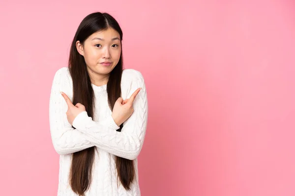 Joven Asiática Mujer Sobre Aislado Fondo Apuntando Los Laterales Teniendo —  Fotos de Stock