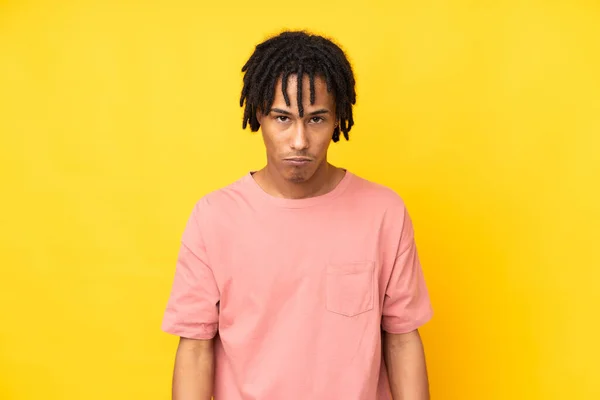 若いアフリカ系アメリカ人の男は悲しいと落ち込んで表現と黄色の背景に隔離された — ストック写真