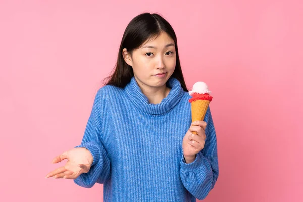 Mladá Asijská Žena Kornetovou Zmrzlinou Izolované Růžovém Pozadí Dělat Pochybnosti — Stock fotografie