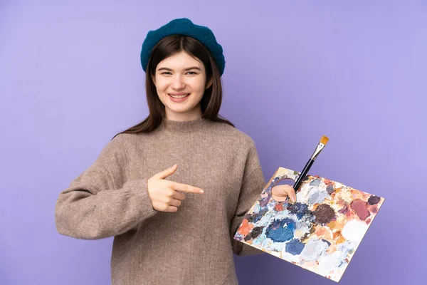Ukraiński Młody Artysta Dziewczyna Trzyma Paletę Odizolowanych Fioletowy Tle Wskazując — Zdjęcie stockowe