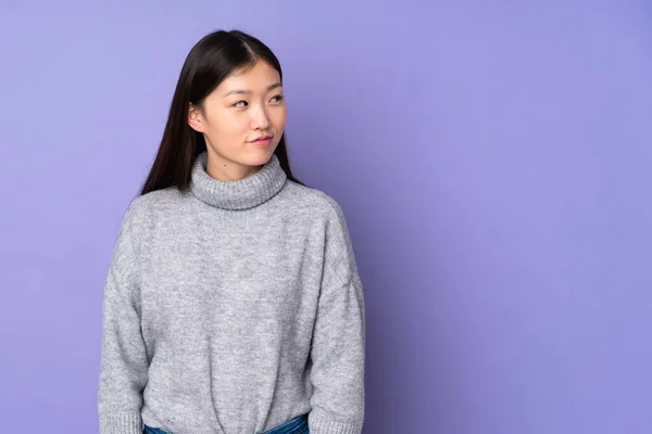Joven Asiática Mujer Sobre Aislado Fondo Teniendo Dudas Mientras Busca —  Fotos de Stock
