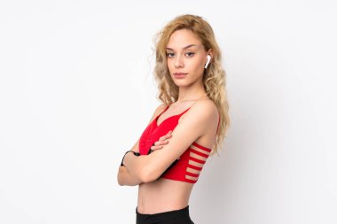 Beyaz arka planda izole genç sarışın kadın kollarını çapraz tutuyor.