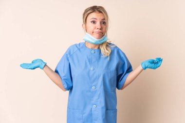 İzole edilmiş arkaplan üzerinde araçları tutan dişçi kadının yüz ifadesi ile ilgili şüpheleri var