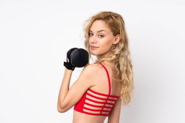 Beyaz arka planda izole edilmiş genç sarışın kadın ağırlık kaldırıyor.