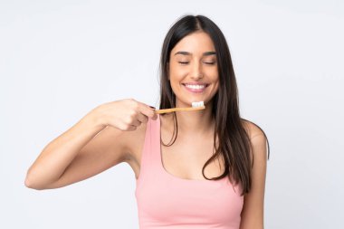 Beyaz arka planda diş fırçası ve mutlu bir ifadeyle izole edilmiş beyaz bir beyaz kadın.