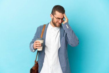 Kafkasyalı genç işadamı mavi arka planda başağrısı ile izole edilmiş.