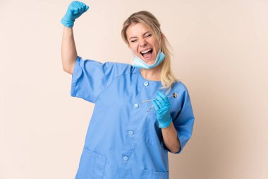 Bir zaferi kutlayan dişçi kadının elinde tecrit edilmiş bir arkaplan var.