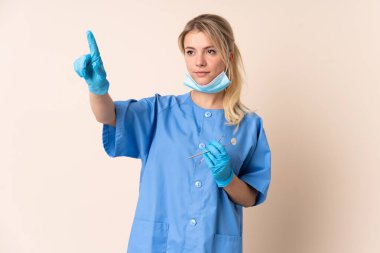 İzole edilmiş arkaplan üzerinde araçları tutan dişçi kadın şeffaf ekrana dokunuyor