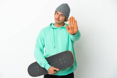 Genç patenci sarışın adam beyaz arka planda izole edilmiş bir şekilde duruyor.