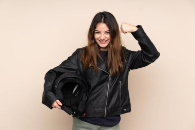 Motosiklet kasklı kadın bej arka planda izole edilmiş bir şekilde zaferi kutluyor.