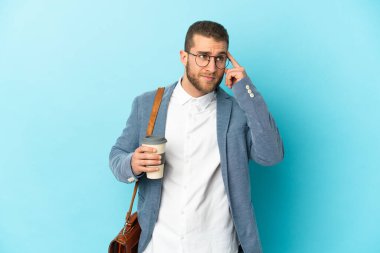 Kafkasyalı genç işadamı, mavi arka planda izole edilmiş. Şüpheleri ve düşünceleri var.