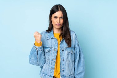 Mutsuz bir ifadeyle mavi arka planda izole edilmiş beyaz bir kadın.