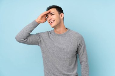 Genç beyaz yakışıklı adam mavi arka planda izole edilmiş gülüyor.