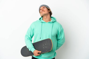 Genç patenci sarışın adam beyaz arka planda izole edilmiş ve yukarı bakıyor.