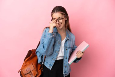 Pembe arka planda izole edilmiş genç beyaz kadın gülüyor.