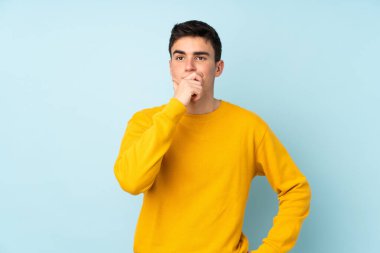 Mor arka planda izole edilmiş beyaz, yakışıklı bir genç. Şüpheleri var ve kafası karışmış bir yüz ifadesi var.