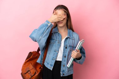 Pembe arka planda izole edilmiş, gözleri elle kaplanmış beyaz bir kadın öğrenci. Bir şey görmek istemiyorum.