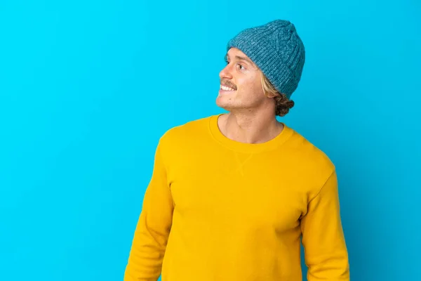 Bonito Homem Loiro Isolado Fundo Azul Olhando Para Lado Sorrindo — Fotografia de Stock