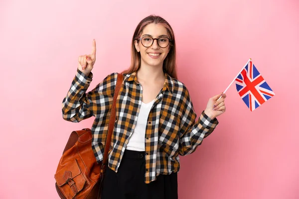 Молодая Латиноамериканка Держащая Флаг Великобритании Розовом Фоне Указывает Отличную Идею — стоковое фото