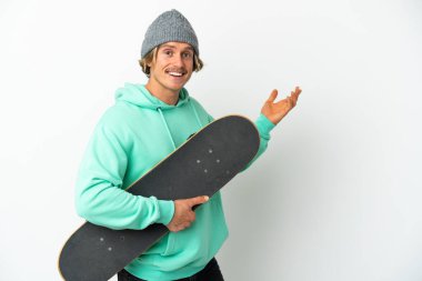 Genç patenci sarışın adam beyaz arka planda izole edilmiş. Davet etmek için ellerini yana uzatıyor.