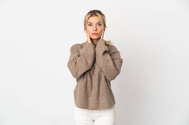 Beyaz arka planda izole edilmiş genç bir Rus kadın hayal kırıklığına uğramış ve kulaklarını kapatmış.