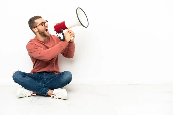 Jovem Homem Bonito Sentado Chão Gritando Através Megafone — Fotografia de Stock