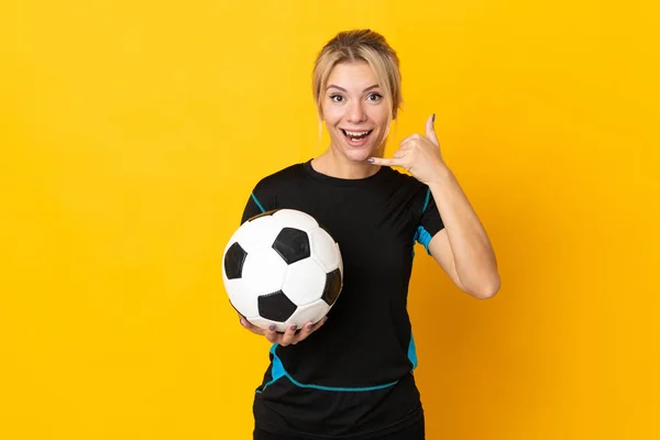 Young Russian football player woman isolated on yellow background making phone gesture. Call me back sign