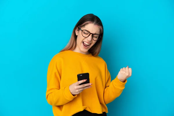 Giovane Donna Caucasica Isolata Sfondo Blu Con Telefono Posizione Vittoria — Foto Stock