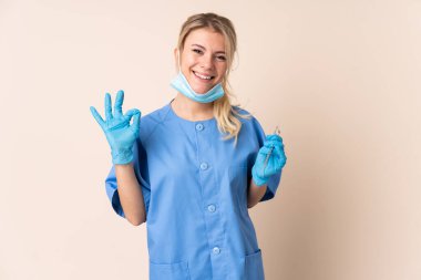 İzole edilmiş arkaplan üzerinde araçları tutan dişçi kadın parmaklarıyla 