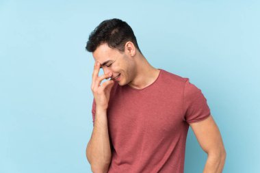 Genç beyaz yakışıklı adam mavi arka planda izole edilmiş gülüyor.