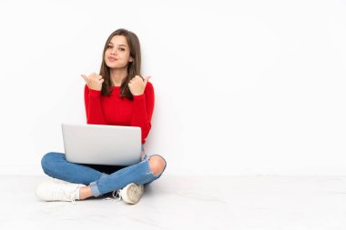 Polisle çalışan hassas kız beyaz arka planda izole edilmiş, başparmakları havada ve gülümsüyor.