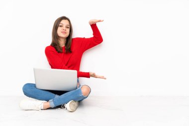 Bilgisayarla çalışan tenaager kız bir reklam eklemek için kopyalama alanı tutan beyaz arkaplan üzerinde izole edildi